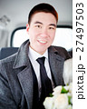 The groom in a winter coat sitting in the car with 27497503