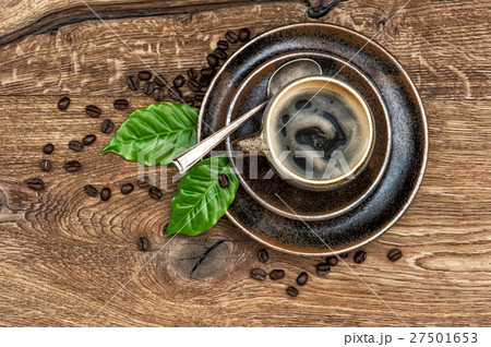 Black coffee beans and leaves on wooden table Black coffee beans and leaves on wooden table 27501653