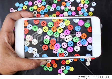Taking a photo of sewing buttons with smart phone 27511641