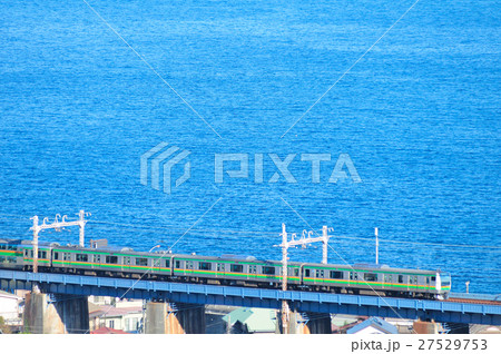 相模湾を望む鉄橋を渡る東海道線E233系電車 27529753