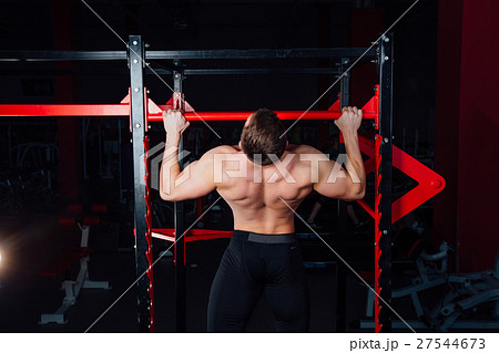 Strong man doing pull ups handsome athlete at gym 27544673