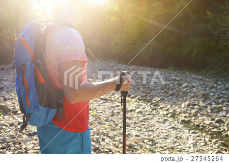 Man hiking with backpac and sticks in mountains Man hiking with backpac and sticks in mountains 27545264
