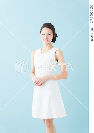 白いワンピースの女性 青背景 の写真素材
