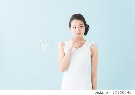 白いワンピースの女性 青背景 の写真素材