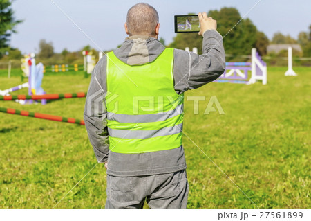 Horse handler take pictures on smart phone 27561899
