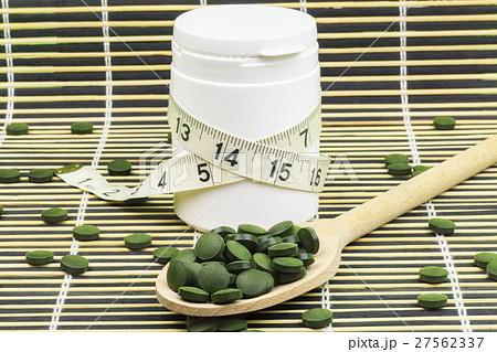 Spirulina,chlorella pills on wood spoon and measur Spirulina,chlorella pills on wood spoon and measur 27562337