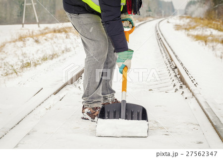 Railroad employee clean snow from the railway cros Railroad employee clean snow from the railway cros 27562347