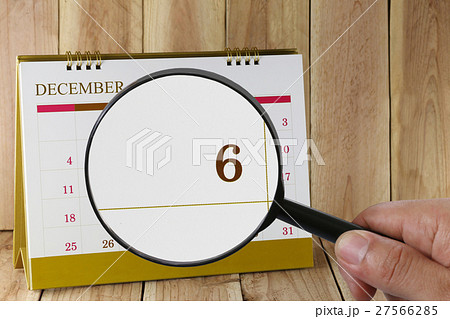 Magnifying glass in hand on calendar you can look sixth date of month,Focus number six in December. Magnifying glass in hand on calendar you can look sixth date of month,Focus number six in December. 27566285