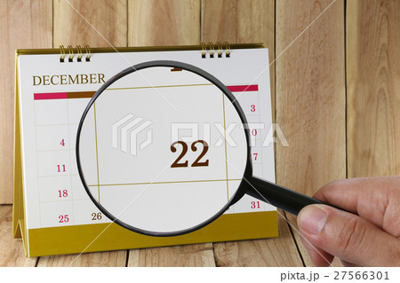 Magnifying glass in hand on calendar you can look Twenty-two date of month,Focus number Twenty-two in December. Magnifying glass in hand on calendar you can look Twenty-two date of month,Focus number Twenty-two in December. 27566301