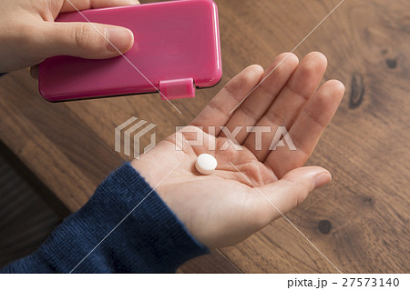 ミントタブレットを食べる女性手元 27573140