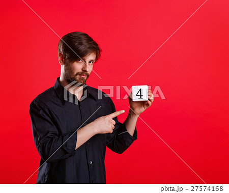 Man holding a cube with the number four 27574168
