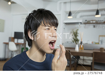 のどスプレーをする男性ポートレート 27576748