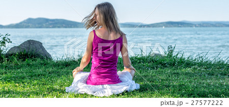 Woman meditating at the lake Woman meditating at the lake 27577222