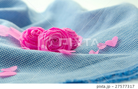 Pink rose and small hart on blue cloth background 27577317