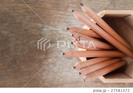 Close up of pencils in holder on wooden background Close up of pencils in holder on wooden background 27581372