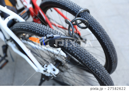 two bikes locked together in city 27582622