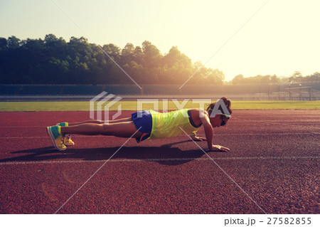young woman runner  push up on stadium track 27582855