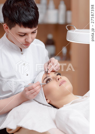 Professional stylist making eyelash extension for 27587398