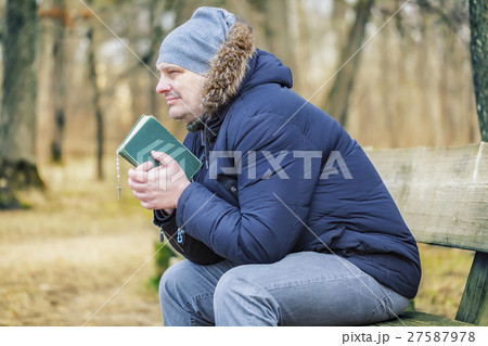 Man with Bible and rosary on bench in the park Man with Bible and rosary on bench in the park 27587978