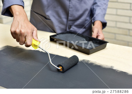 young man painting a wooden board 27588286