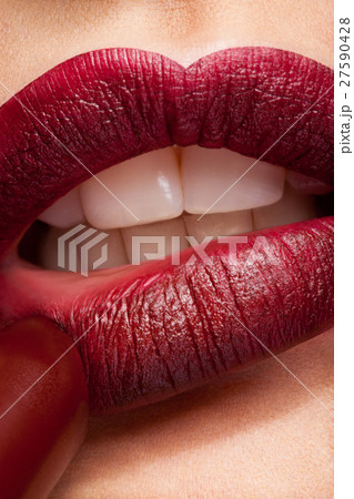 Applying lipstick on red lips 27590428