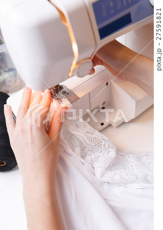 Seamstress makes stitch on sewing-machine 27591821