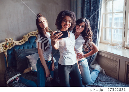 Three pretty girls grimace and make selfie on the 27592821