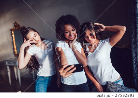 Three pretty girls grimace and make selfie on the 27592893