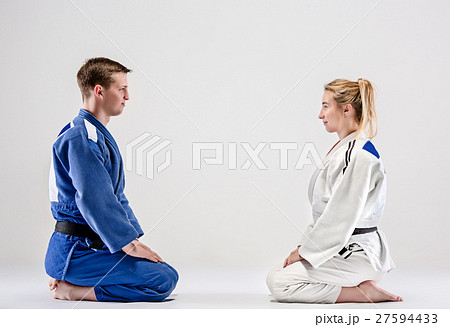 The two judokas fighters posing on gray The two judokas fighters posing on gray 27594433