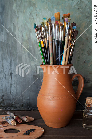 Paintbrushes in jug, palette and paint tubes 27595349