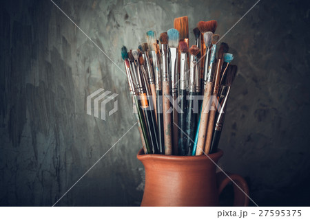 Paintbrushes in a jug from potters clay. Paintbrushes in a jug from potters clay. 27595375