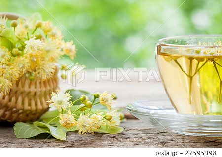 Cup of linden tea and wicker basket with lime flowers, herbal me 27595398