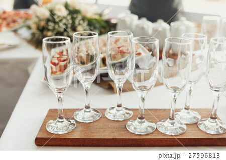 Empty champagne flutes stand on wooden board Empty champagne flutes stand on wooden board 27596813