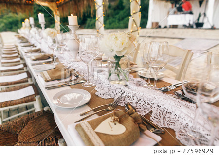 Long white table stands under white tents Long white table stands under white tents 27596929