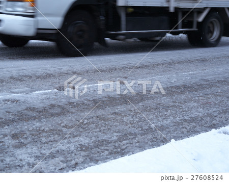 シャーベット状の道路を走行するトラック 27608524