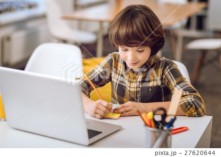 Little boy writing notes with pensil. 27620644