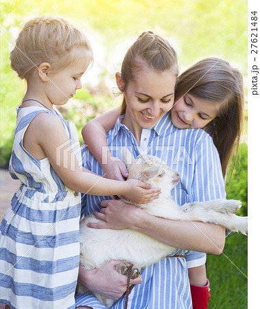 Happy mother and her daughters with baby goats Happy mother and her daughters with baby goats 27621484
