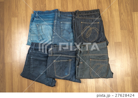 Blue jeans on a brown wooden background Blue jeans on a brown wooden background 27628424