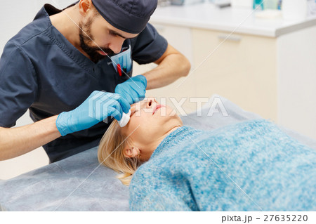 marking face of elderly woman old of plastic surgery at receptio 27635220