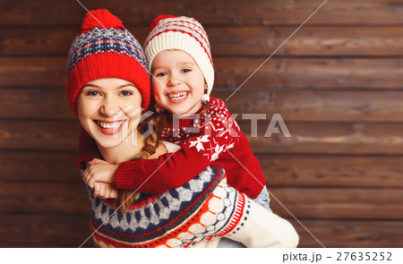 happy family mother and child girl hugs at wooden background. happy family mother and child girl hugs at wooden background. 27635252