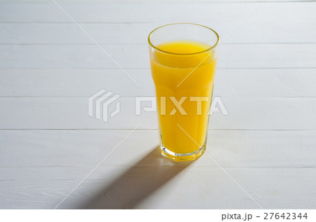 glass of juice on a table. glass of juice on a table. 27642344