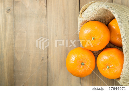 oranges in gunny sack on wood table top 27644971