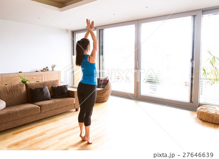 Young woman exercising at home, stretching legs 27646639