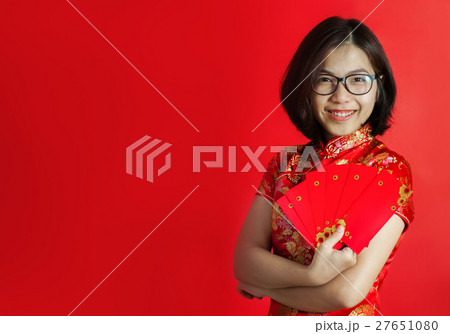 Asian woman with cheongsam holding red envelopes. Asian woman with cheongsam holding red envelopes. 27651080