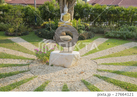 silver buddha statue with golden robe in garden 27664121