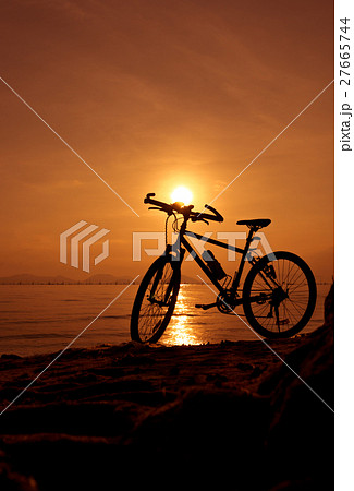 Silhouette of bicycle on the beach against sunset Silhouette of bicycle on the beach against sunset 27665744