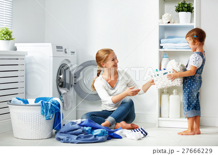 family mother and child girl in laundry room near washing machi family mother and child girl in laundry room near washing machi 27666229