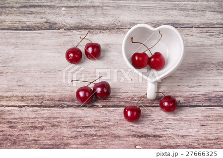 Cherries Chile and Heart-shaped mug on wooden. Cherries Chile and Heart-shaped mug on wooden. 27666325