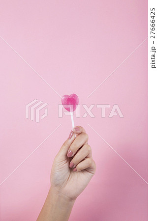 Women hand holding heart lollipop  27666425