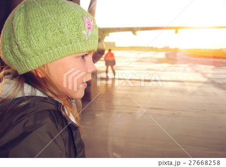 Little girl looking through the airport window. Little girl looking through the airport window. 27668258